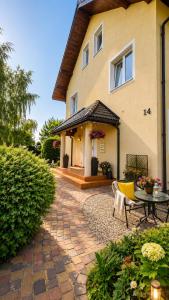 a house with a patio and a table in front of it at Szept Fal & Minigolf in Rewal