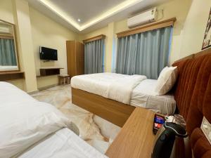 a hotel room with two beds and a table at Hotel Skyline in Janakpur