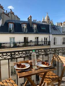 a table with two plates of food on a balcony at Chambre à Montmartre in Paris