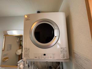 a washing machine with a mirror in a room at HAMARs ITOMAN HOUSE - ReFaｼｬﾜｰﾍｯﾄﾞ&ﾄﾞﾗｲﾔｰ完備 - 南部観光の拠点 - 1日1組限定 in Itoman