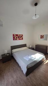 a bedroom with a bed with two night stands and two tables at Mari del sud in Bagheria