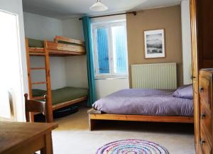 a bedroom with two bunk beds and a table at Oustal de Bourdeaux in Bourdeaux