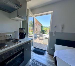 a kitchen with a stove and a door to a patio at Comfort in Bamberg
