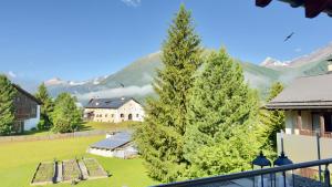 a view from a balcony of a house and trees at Alpine Home with Lounge - 10 min from St Moritz in La Punt-Chamues-ch