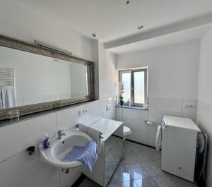 a white bathroom with a sink and a mirror at Comfort in Bamberg +13 photos