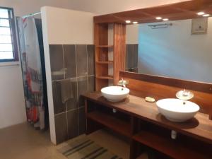 a bathroom with two sinks and a large mirror at Villa Armor in Nosy Be