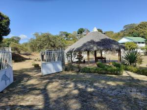 a pavilion with a thatch roof and a gate at Villa Armor in Nosy Be