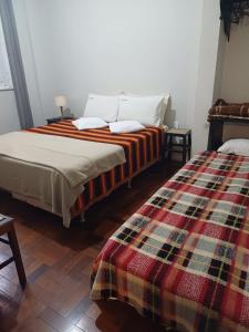 a bedroom with two beds and a blanket at Mezanino 131 in Ouro Preto