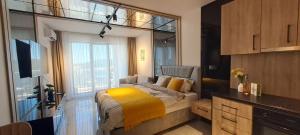 a bedroom with a bed with a yellow blanket at Infinity Studio, Shkorpilovtsi in Shkorpilovtsi