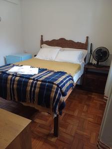 a bedroom with a bed with a blue and yellow blanket at Mezanino 131 in Ouro Preto +7 photos