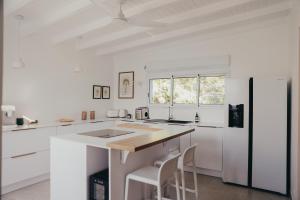 a kitchen with white cabinets and a wooden counter top at La petite villa in Le Gosier