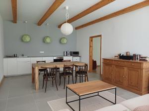 a kitchen and dining room with a wooden table and chairs at Füveskert in Erdőbénye