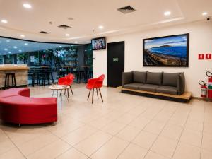 a lobby with a couch and chairs and a bar at ibis Santos Gonzaga Praia in Santos