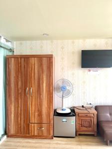 a living room with a brown cabinet and a fan at Chillax in Ha Long