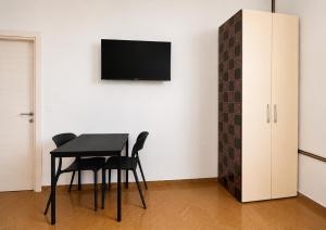 a dining room with a table and a tv on a wall at A&D BnB in Porretta Terme