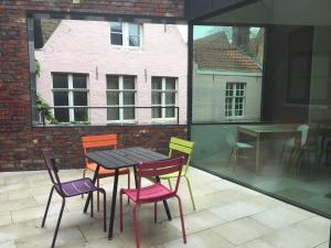 a table and chairs on a patio with a window at B-Square in Bruges