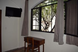 a room with a desk and a window at Hotel San Jose Centro Historico in San Luis Potosí