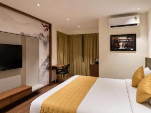 a hotel room with a bed and a television at Hotel Elite Executive Lodging in Bārāmati