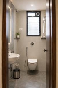 a bathroom with a toilet and a sink and a window at Hotel Elite Executive Lodging in Bārāmati +33 photos