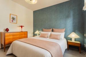 a bedroom with a large bed with a green accent wall at Wanderlust Experience Mood Apartment in Bitonto