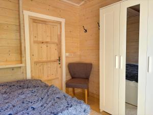 a bedroom with a bed and a chair at Älg Stuga in Kosta