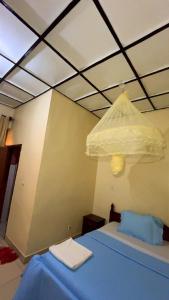 a bedroom with a blue bed and a ceiling at piece motel in Kigali