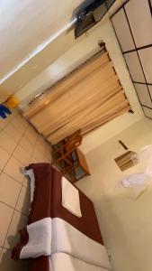 a room with a bed in a kitchen with a window at piece motel in Kigali