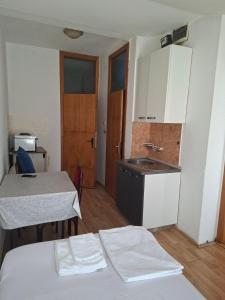 a small kitchen with a bed and a sink at Apartmani Lazić No 9 in Gracanica