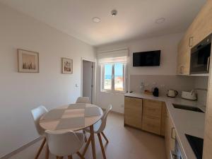 a kitchen with a table and chairs in a kitchen at Dianamar in Albufeira