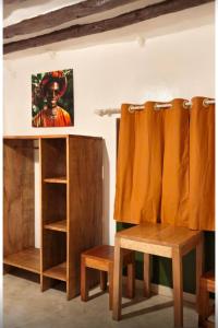 a room with wooden furniture and a painting on the wall at One Love Garden Villas Paje in Kiganga