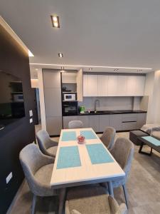 a living room with a table and chairs and a kitchen at Beach House Lleshi in Tale