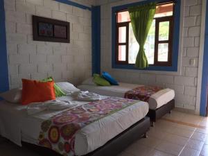 a bedroom with two beds and a window at Hotel Miramar Capurganá Puerto in Capurganá