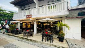 a restaurant with tables and chairs in front of a building at Hotel Miramar Capurganá Puerto in Capurganá