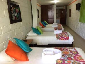 a group of four beds in a room at Hotel Miramar Capurganá Puerto in Capurganá