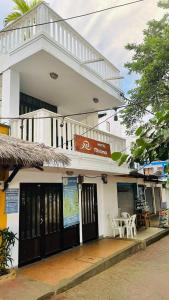a white building with black doors and a table at Hotel Miramar Capurganá Puerto in Capurganá
