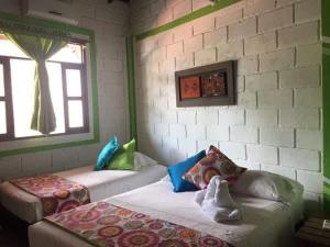 a room with a bed and a window and a wall at Hotel Miramar Capurganá Puerto in Capurganá