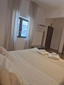 a bedroom with a large white bed with towels on it at Cloud9 Airport Suites in Koropi +55 photos