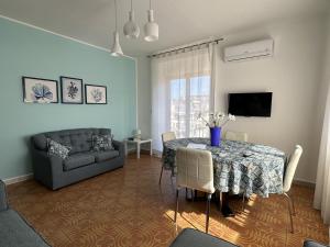 a living room with a table and a couch at Casa Maccers in Giardini Naxos