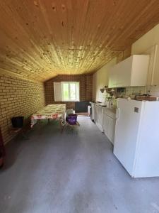 a large kitchen with a table and a refrigerator at Vikendica in Bezdan