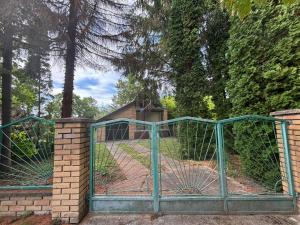 a gate to a garden with a house behind it at Vikendica in Bezdan +8 photos