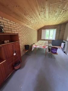 a room with a table and chairs and a brick wall at Vikendica in Bezdan