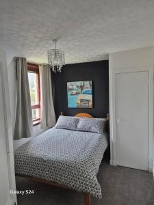 a bedroom with a bed and a chandelier at Millers Ben Nevis View in Caol +10 photos