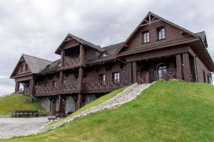 duży drewniany dom na szczycie wzgórza w obiekcie Karczma Zamojszczyzna w mieście Zamość