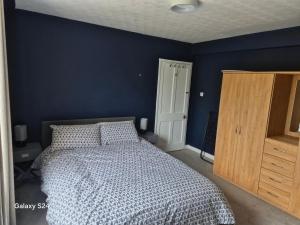 a bedroom with a bed and a blue wall at Millers Ben Nevis View in Caol