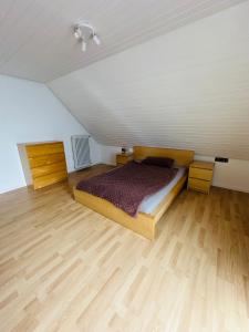 a bedroom with a bed and a wooden floor at FeWo Ruf in Sasbach am Kaiserstuhl