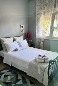 a bedroom with a large white bed with a window at Elenas house in Kánithos