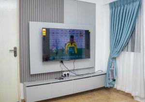 a tv in a living room with a tv screen at Mycom Apartment in Kumasi