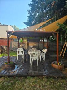 a wooden deck with chairs and tables and a gazebo at Ferienwohnung 1 am Bahnhof in Bernburg