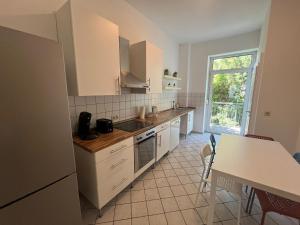 a kitchen with white cabinets and a table and a window at Süße Marie 19 - Coffee for free - in Karlsruhe
