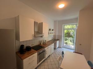 a kitchen with white cabinets and a table and a window at Süße Marie 19 - Coffee for free - in Karlsruhe +36 photos
